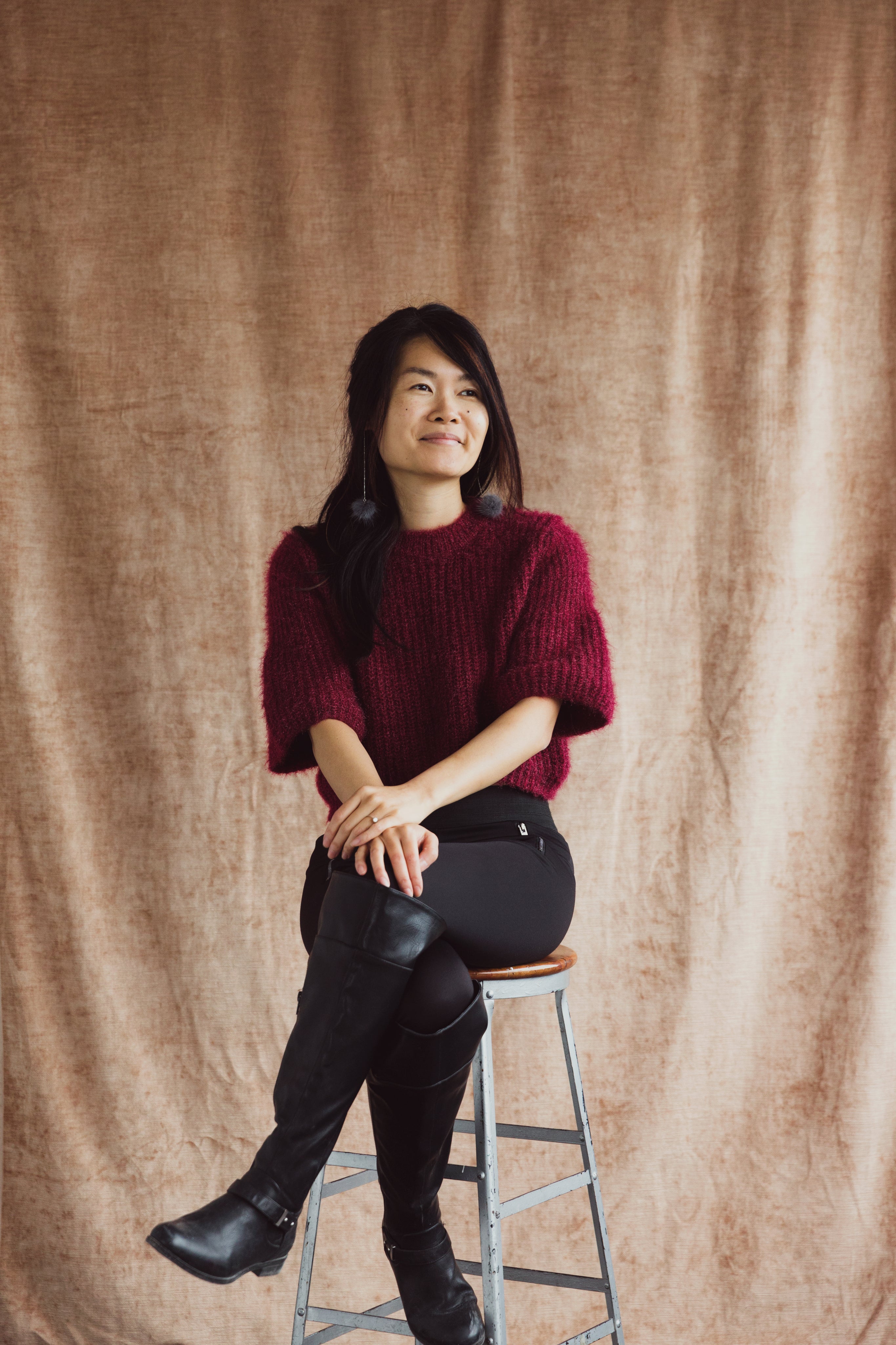 a-model-perched-on-a-stool-smiles.jpg